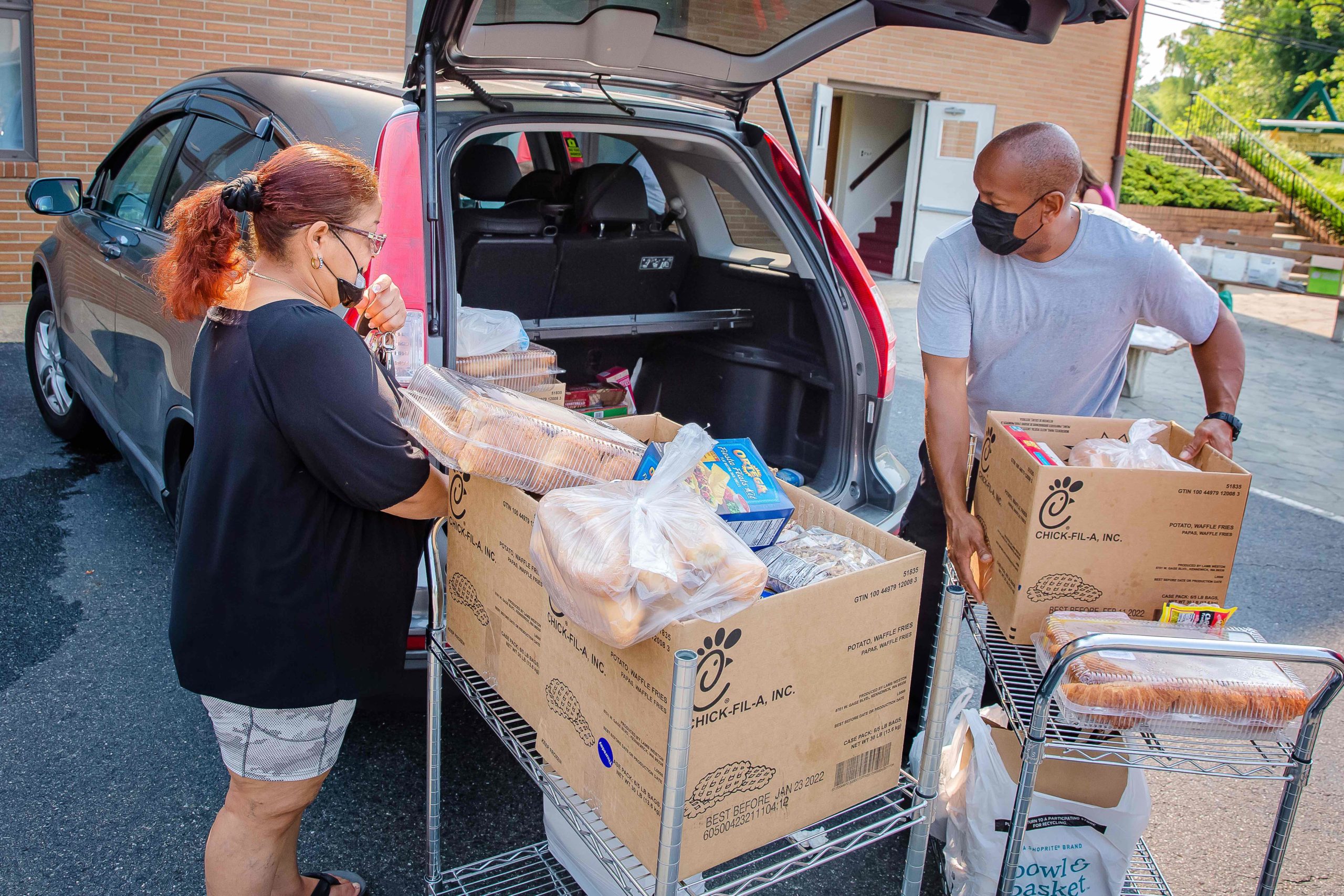 LMP-20210706-FBSNJ_Woodbury-020F-scaled Couple unloading the trunk of a car with food boxes