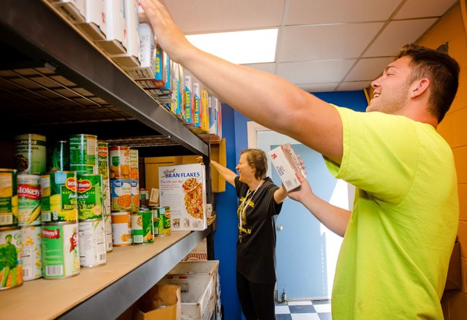 two people stocking a food pantry