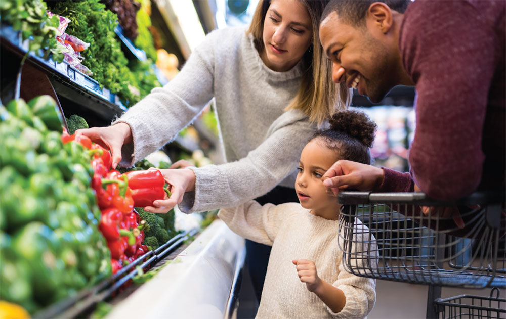 SNAP mom, dad and child picking produce at the store
