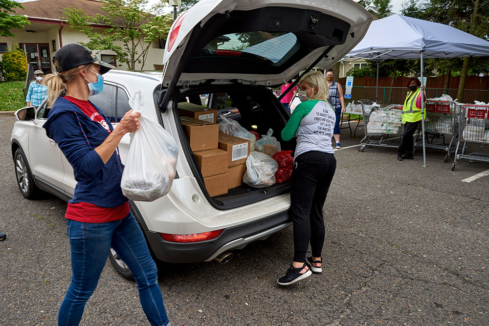 Mobile-Distributions-Main two women filling the trunk of their car with food