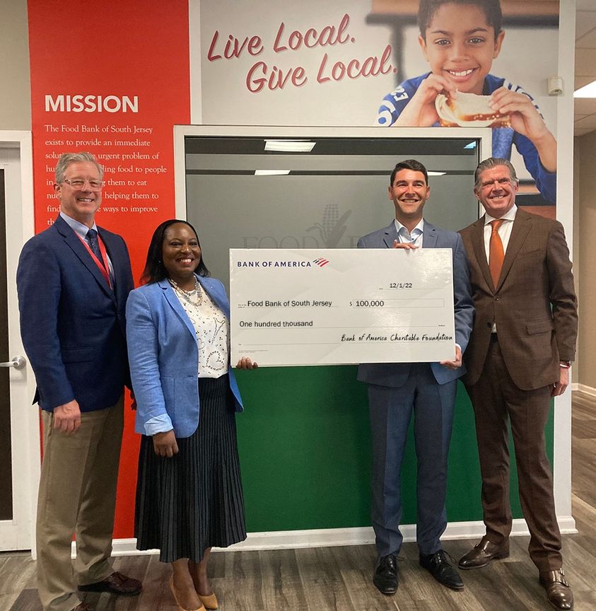 Fred Wasiak and Lavinia Awosanya from the Food Bank of South Jersey accept a check from Philip J. Bartholomew and Jim Dever from Bank of America