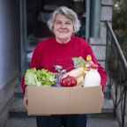 portrait of happy senior woman received crate with freshness food at home.